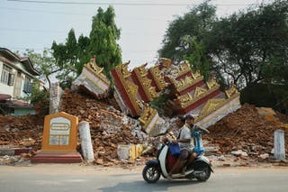 Os habitantes locais passam por um prédio desmoronado após um terremoto em Mandalay, Myanmar (Myo Kyaw Soe/Xinhua via AP)